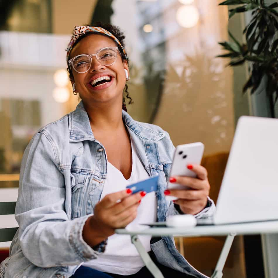 Image of young woman using her credit card in cafe.